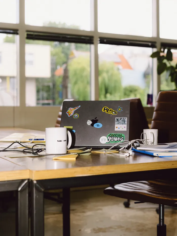 The 1table studio table with a stickered laptop and mugs