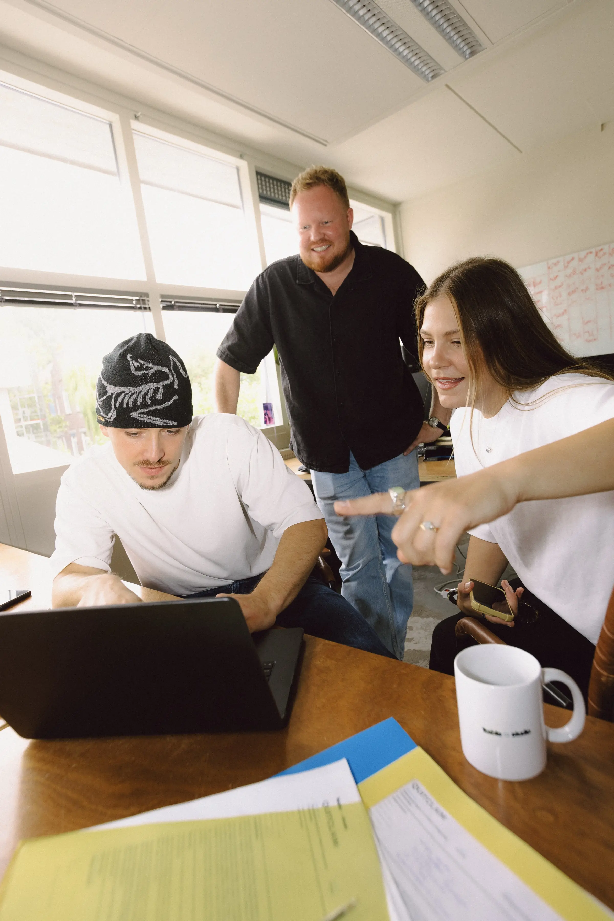 The 1Table team around a laptop in the studio